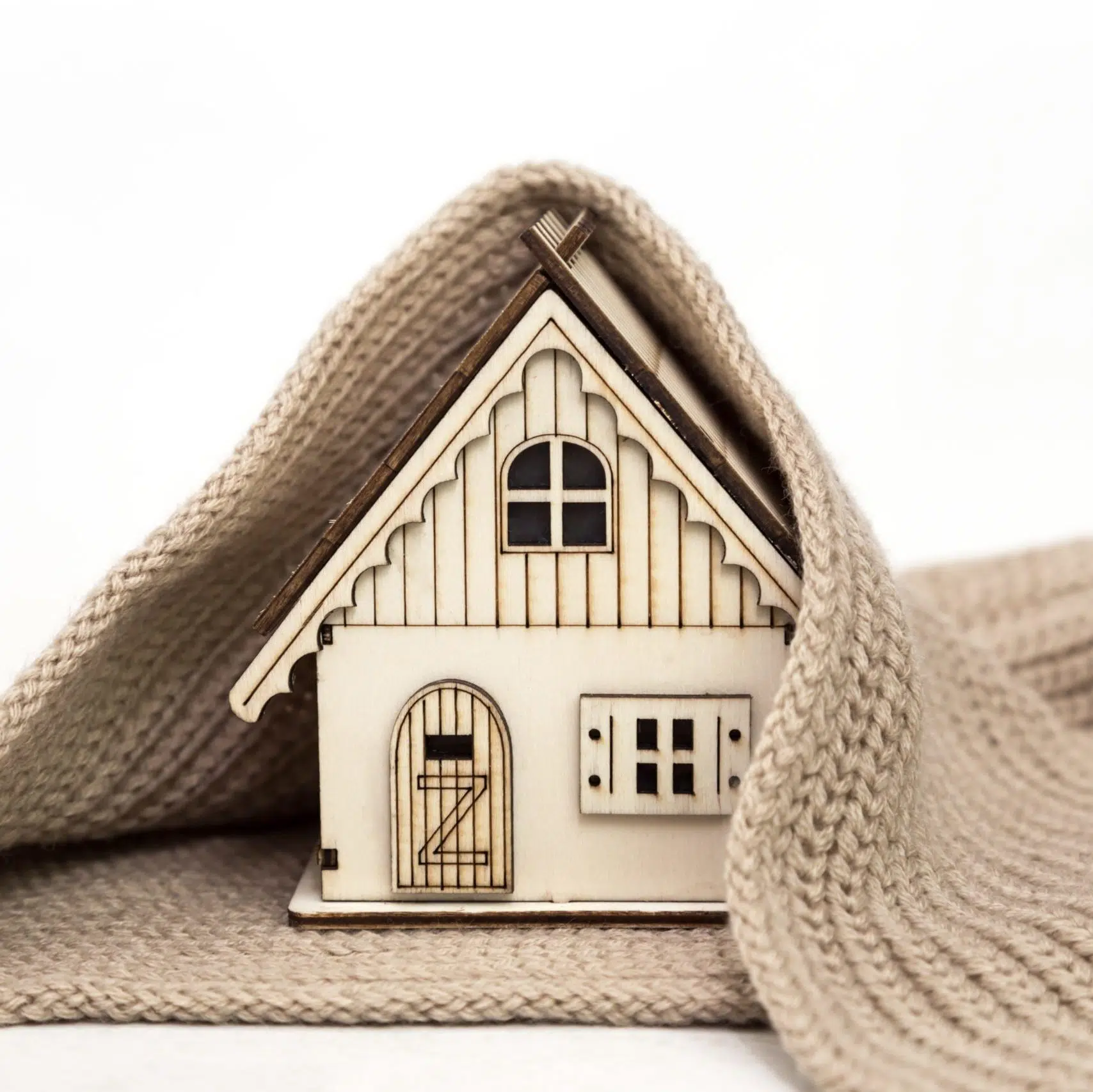 toy-wooden-house-wrapped-in-a-warm-knitted-scarf-on-a-white-background-business-concept-buy_t20_pxAoBj-scaled-e1594057951901.jpg
